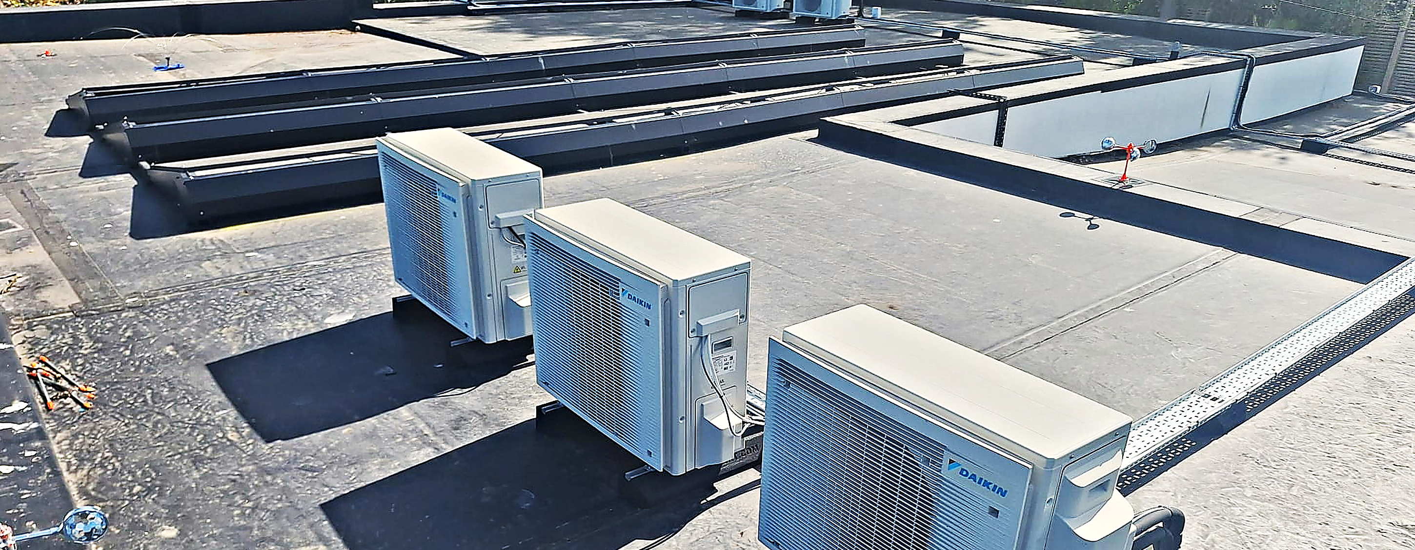 Three Daikin condenser units installed together on a flat roof