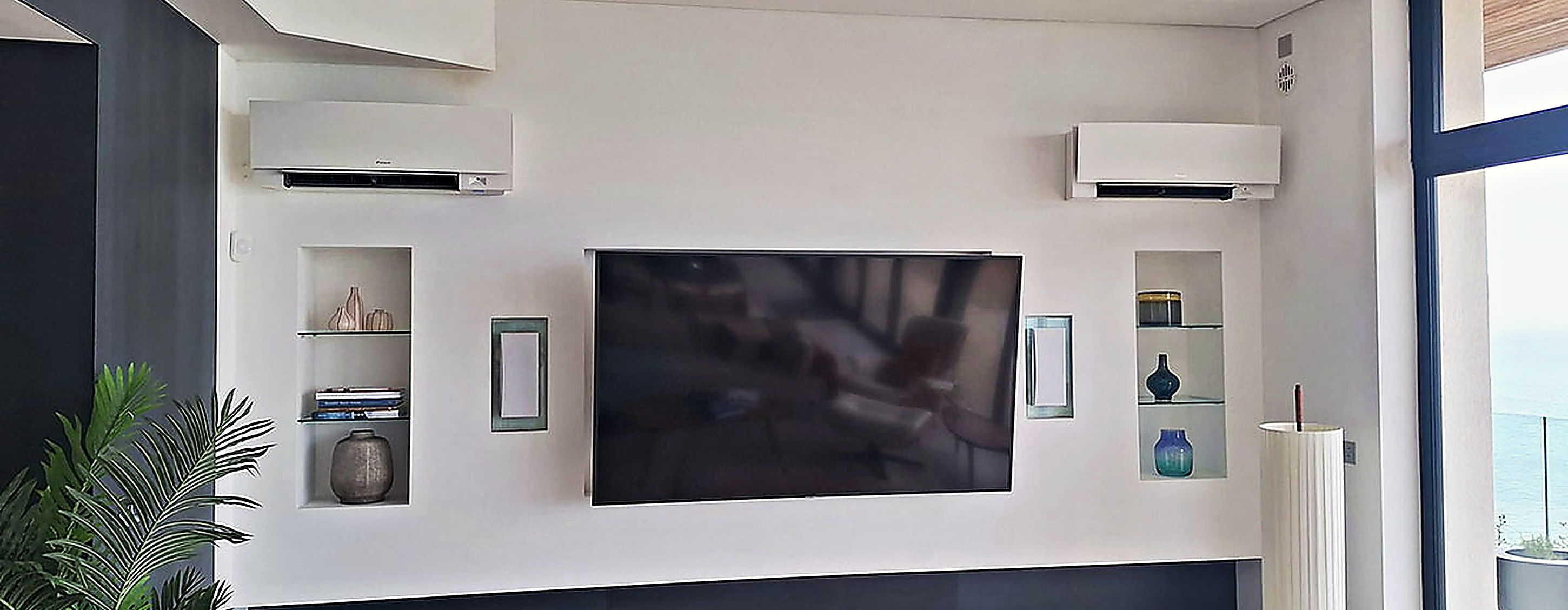 Two wall mounted air conditioning units in a coastal living room with a sea view