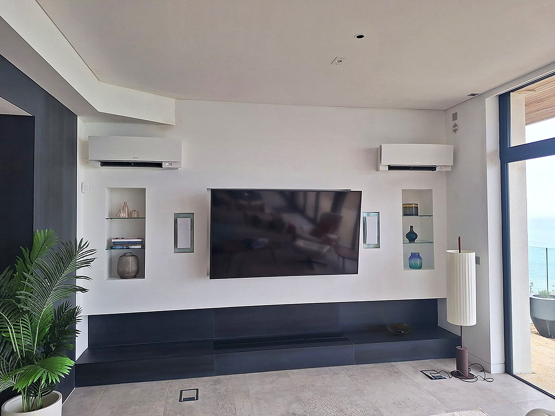 Two wall mounted units in a coastal living room with a sea view