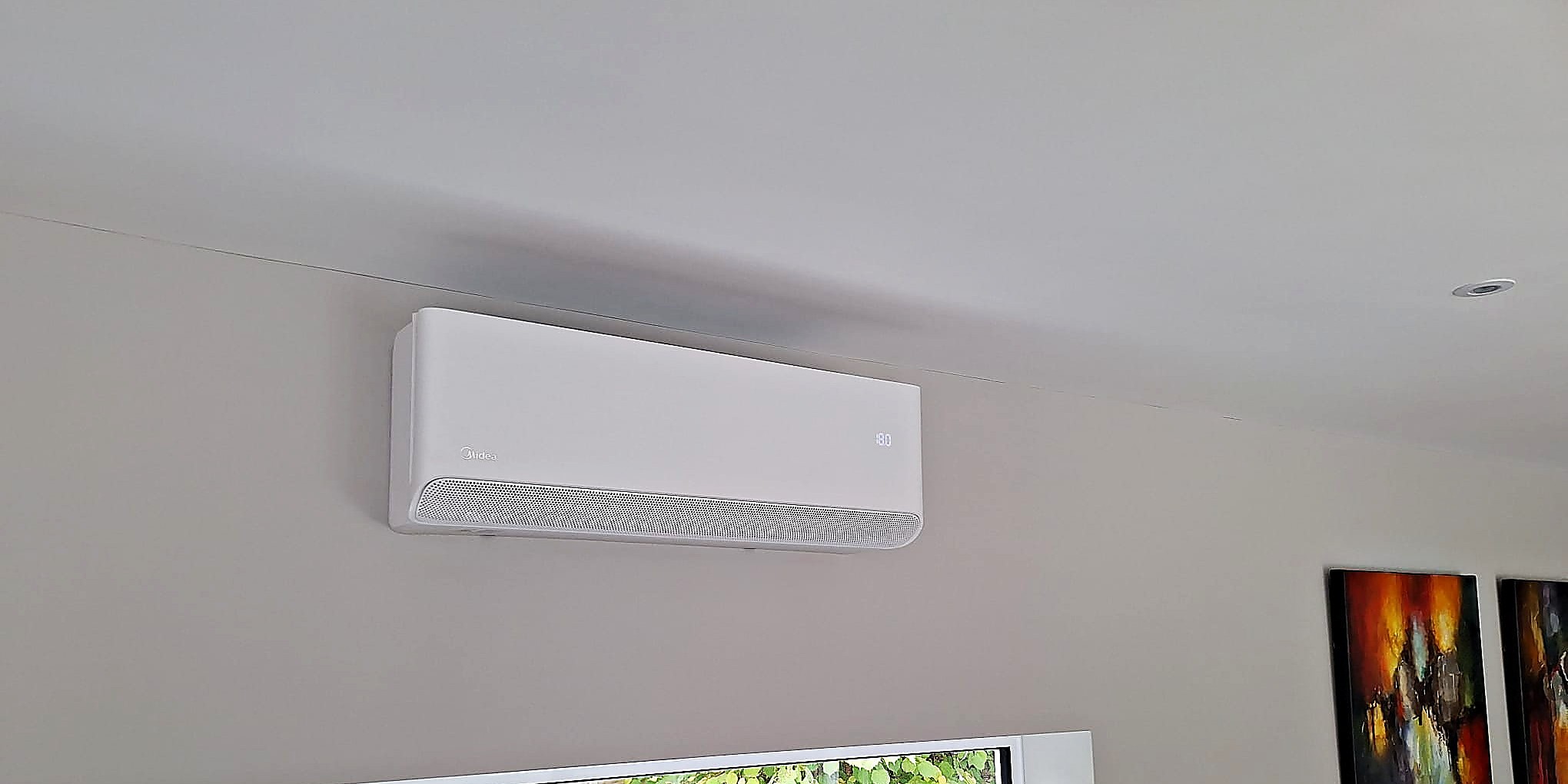 Wall mounted indoor unit above a long picture window