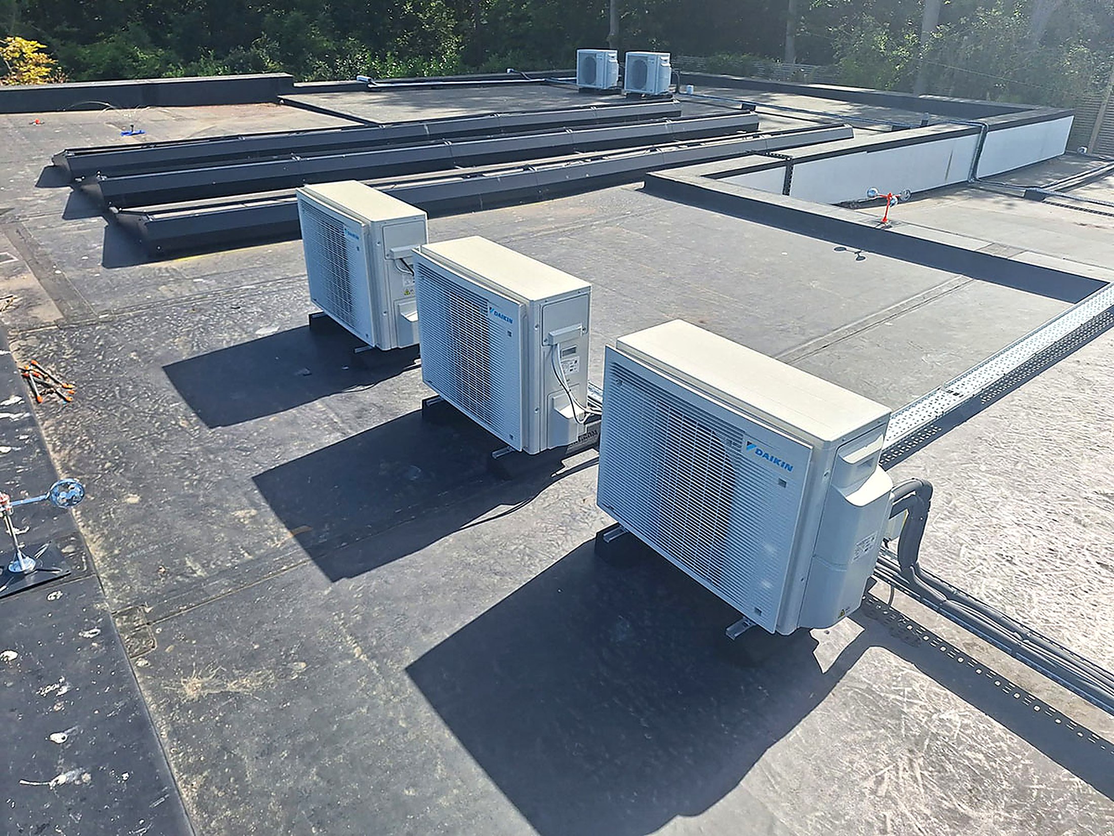 Four Daikin condensers on a commercial flat roof